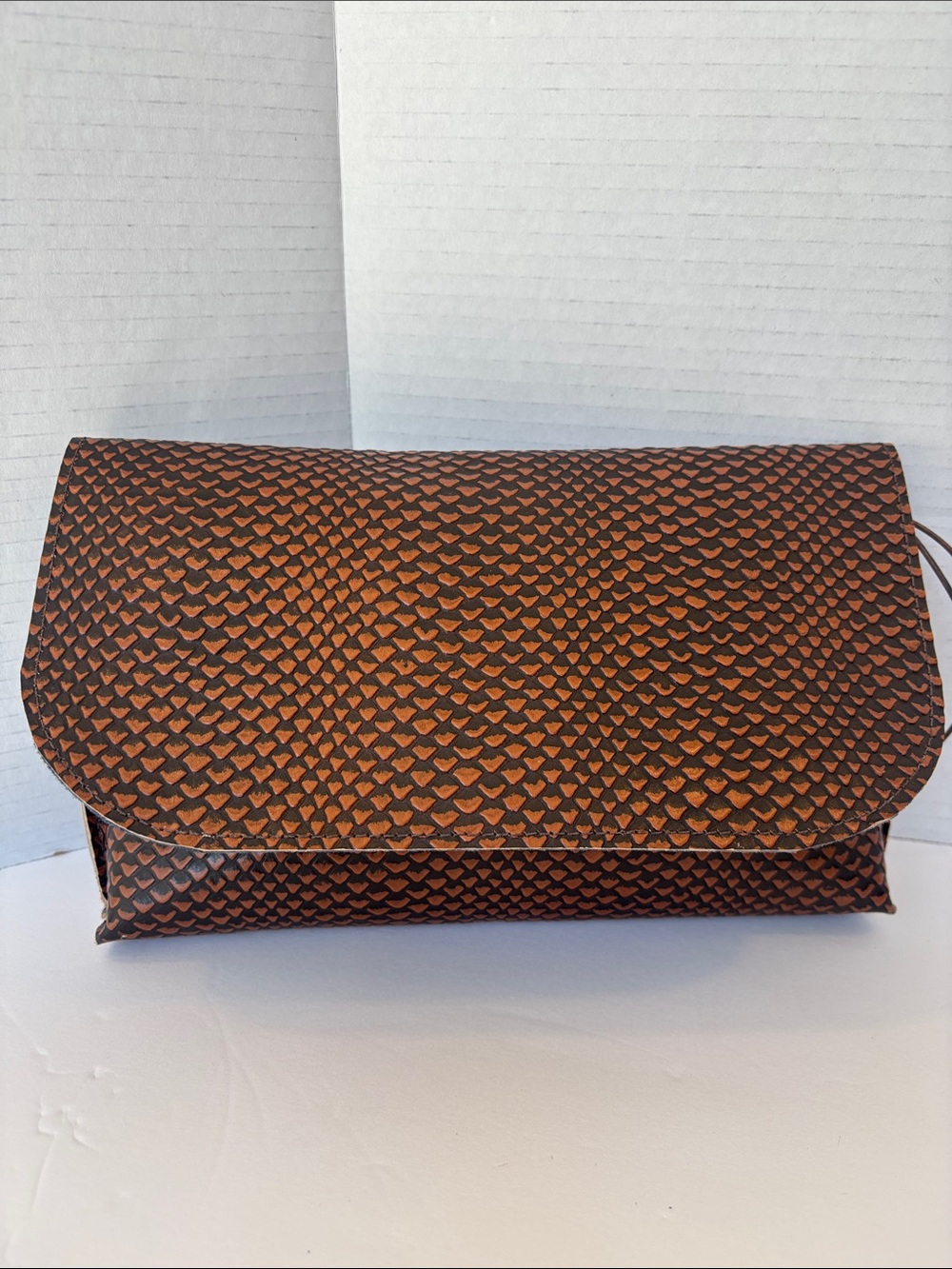 b. may embossed brown leather clutch bag